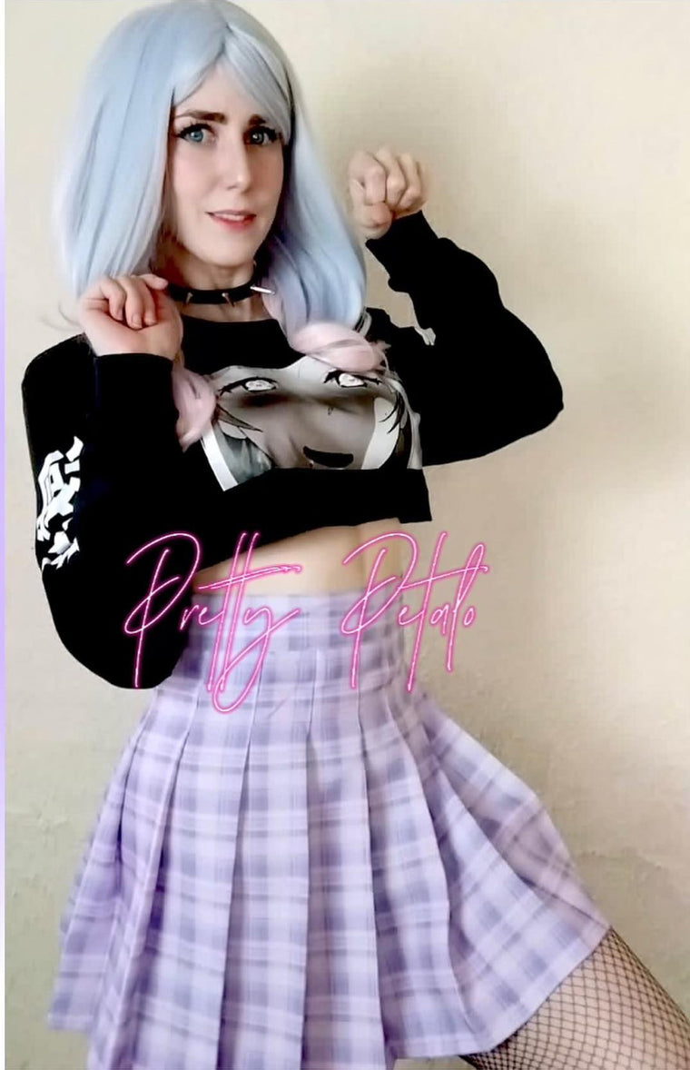 Person wearing a black crop top with a graphic design and a plaid skirt, with 'Pretty Pretty' text overlay.